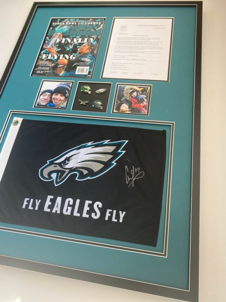 Framed Eagles memorabilia, a flag, pins, photos and a Sports Illustrated Cover