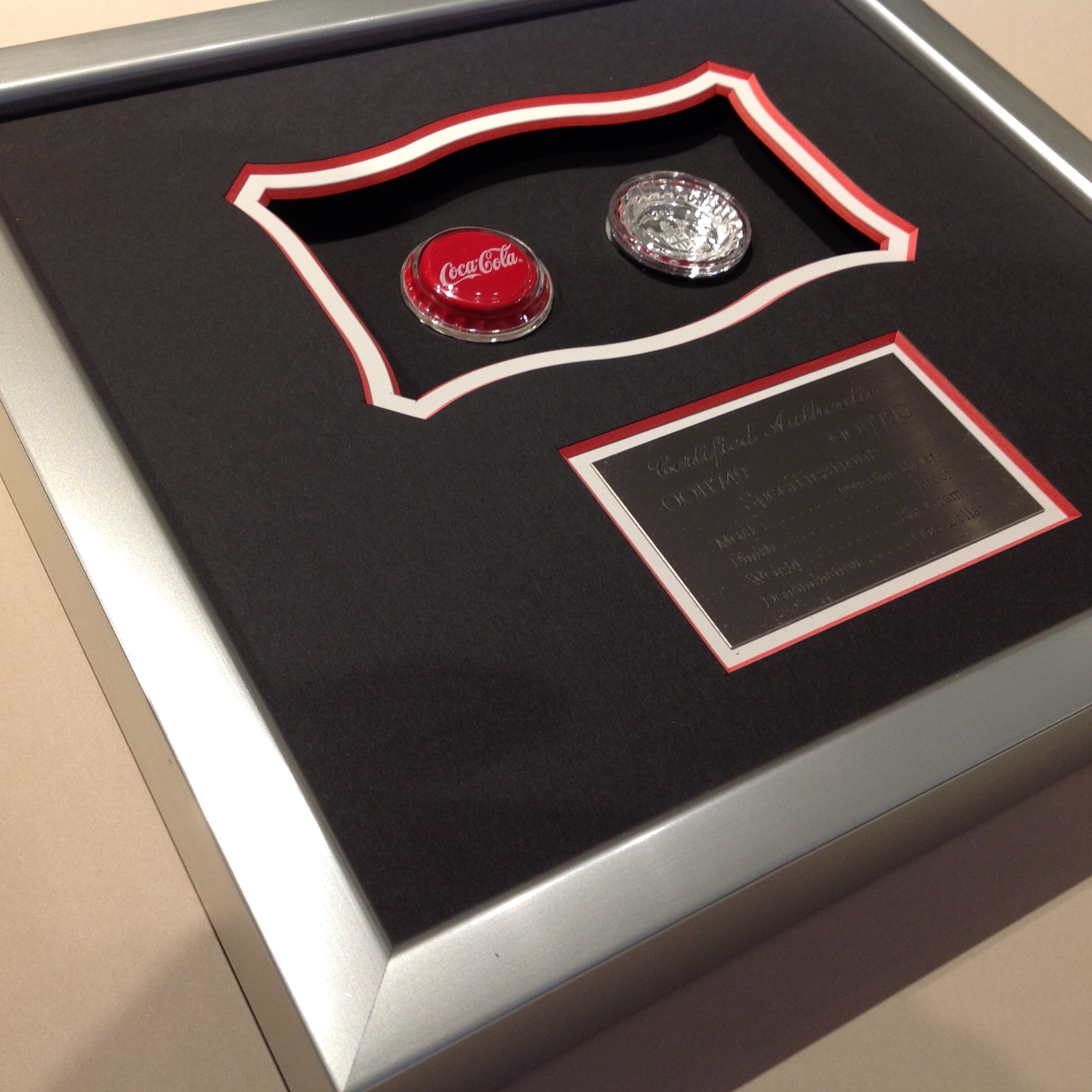 We framed Coke memorabilia ina a custom shadowbox with and engraved plaque.