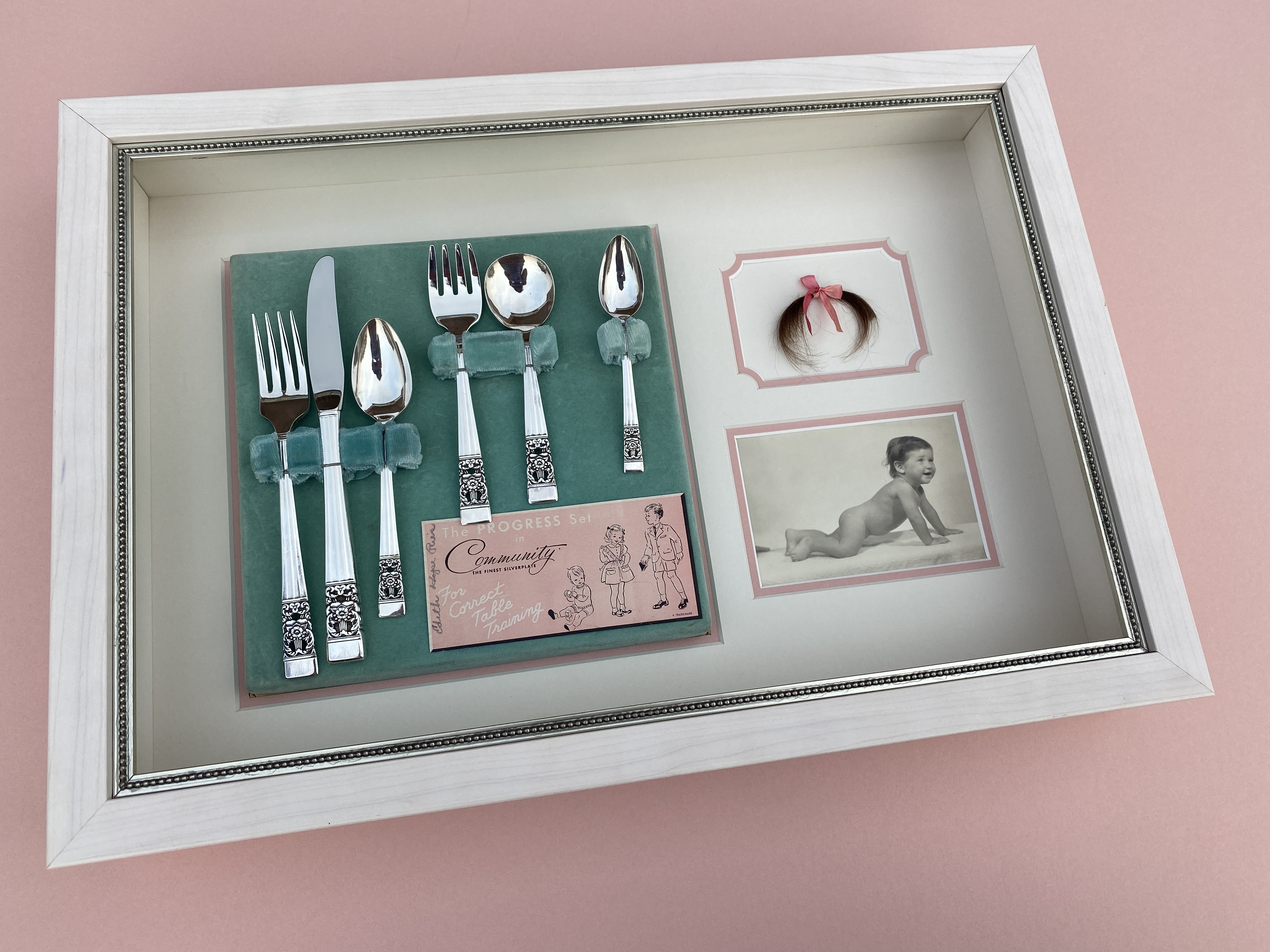 Custom framed Shadowbox including a lock of hair, baby photo and child’s silverware set with Museum Glass in a Larson Juhl Frame
